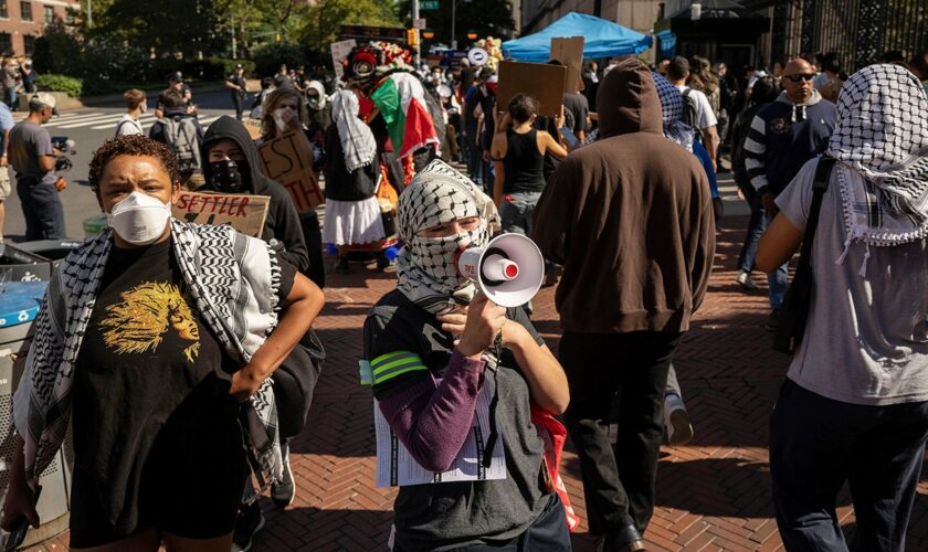 Masked anti-Israel protesters at Columbia University demonstrate as students check in for first day of classes