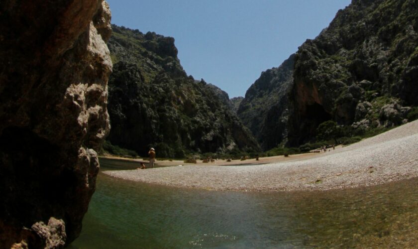 People sunbath at the "Torrent de Pareis" canyon, part of the cultural landscape of the Sierra de Tramuntana, on the northwestern coast of the Spanish Balearic island of Mallorca June 28, 2011. The cultural landscape of the Sierra de Tramuntana (Tramuntana mountain range) was inscribed on UNESCO's World Heritage List on Monday. REUTERS/ Enrique Calvo (SPAIN - Tags: ENVIRONMENT TRAVEL SOCIETY)