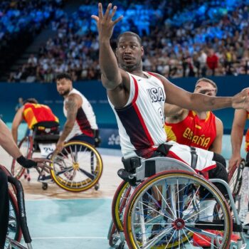 L'Américain Brian Bell (c) passe le ballon sous le regard de L'Espagnol Manuel Lorenzo (g) pendant le tour préliminaire du groupe B du match de basket-ball en fauteuil roulant entre les États-Unis et l'Espagne pendant les Jeux paralympiques de Paris 2024 à Paris, le 29 août 2024