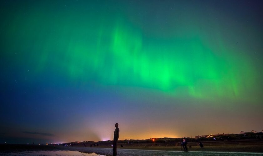 The aurora borealis, also known as the northern lights, glow on the horizon at Another Place by Anthony Gormley, Crosby Beach, Liverpool , Merseyside . Picture date: Friday May 10, 2024. PA Photo. See PA story WEATHER Aurora. Photo credit should read: Peter Byrne/PA Wire