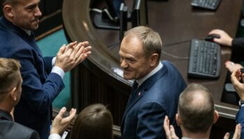 Le chef élu du nouveau gouvernement polonais Donald Tusk (c) applaudi après son discours au Parlement, le 12 décembre 2023 à Varsovie