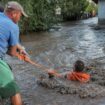 Rescuers pull a man through flooded water and to safety in Romania amid the ongoing floods. Pic: Reuters