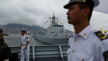 Des marins chinois à bord du Yinchuan, un destroyer de type 052D de la marine de l'Armée populaire de libération (APL), surveillent les visiteurs tandis que le destroyer de type 052C de la marine de l'APL Jinan (C, arrière-plan) est exposé au public à la base navale de Ngong Shuen Chau à Stonecutters.