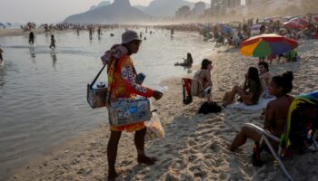 Un vendeur ambulant propose du thé au maté sur la plage d'Ipanema, à Rio de Janeiro, au Brésil, le 8 août 2024