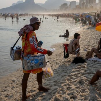 Un vendeur ambulant propose du thé au maté sur la plage d'Ipanema, à Rio de Janeiro, au Brésil, le 8 août 2024