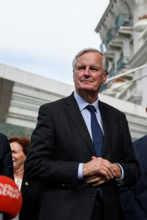 Le Premier ministre français Michel Barnier (C) s'adresse aux journalistes après avoir été accueilli par le chef du groupe parlementaire du parti Les Républicains (LR) au Sénat, à Paris, le 12 septembre 2024