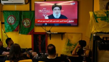 People watch the speech of Hezbollah leader Hassan Nasrallah as they sit in a cafe in the southern suburbs of Beirut, Thursday, Sept. 19, 2024. (AP Photo/Hassan Ammar)