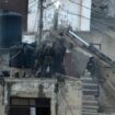 Israeli soldiers look over a rooftop where two bodies lie motionless in the West Bank town of Qabatiya. Pic: AP