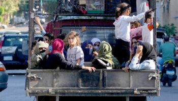 Lebanese citizens who fled from the southern villages sit in a pickup in Beirut. Pic: AP