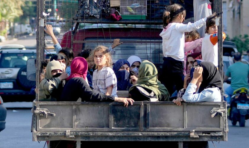 Lebanese citizens who fled from the southern villages sit in a pickup in Beirut. Pic: AP