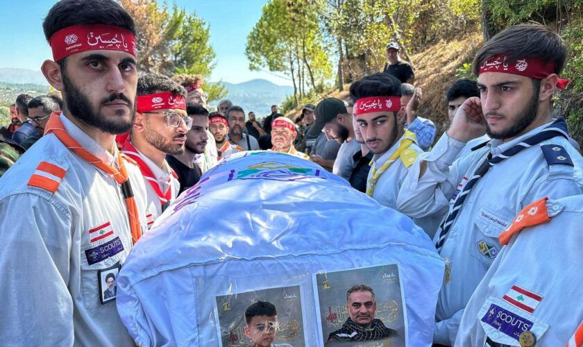 The coffin of a young boy is carried