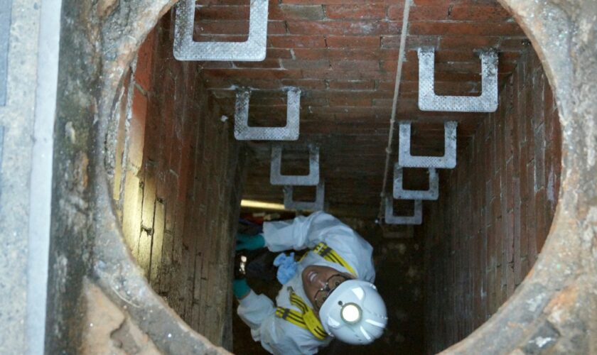 A Thames Water employee climbs down into a sewage pipe in London. File pic: PA