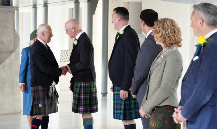 The King shakes hands with First Minister John Swinney. Pic: PA