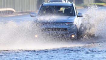 Cars drive along a flooded road as heavy rain continues to cause flooding in areas of the country, in southwest London, Britain, September 26, 2024. REUTERS/Toby Melville