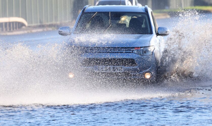 Cars drive along a flooded road as heavy rain continues to cause flooding in areas of the country, in southwest London, Britain, September 26, 2024. REUTERS/Toby Melville