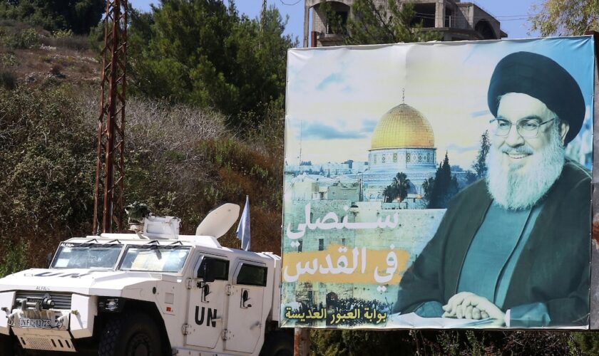 Un véhicule blindé des Nations unies patrouille près d'un panneau publicitaire avec un portrait de Hassan Nasrallah, dans le sud du Liban, le 30 août 2023