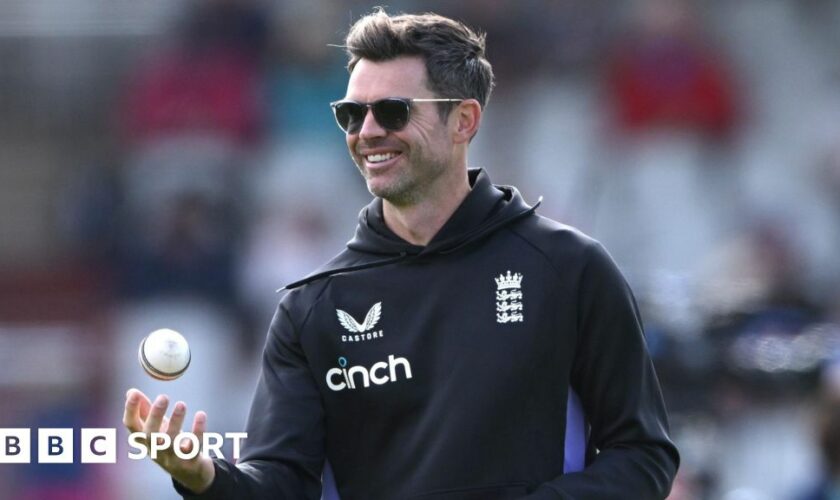 James Anderson tosses a white ball in the air while on coaching duties for England