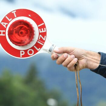 Polizeikelle mit "Stop"-Beschriftung an einem Grenzübergang