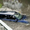 Cars and rail lines submerged as flood risk persists