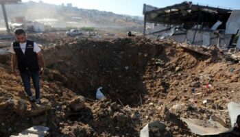 Ein libanesischer Polizist steht in der Nähe eines Kraters nach einem israelischen Luftangriff auf einen Hangar im Südlibanon. F