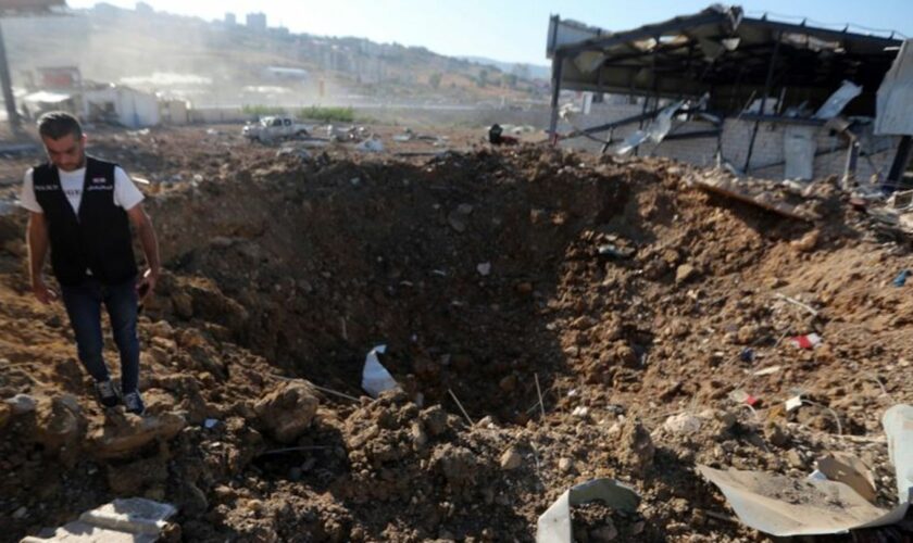 Ein libanesischer Polizist steht in der Nähe eines Kraters nach einem israelischen Luftangriff auf einen Hangar im Südlibanon. F