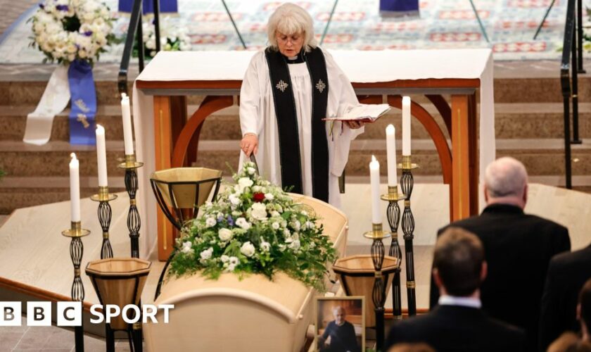 A priest stands next to the coffin of Sven-Goran Eriksson