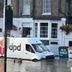 Hilarious moment heroic delivery van driver braves deep floodwater to make sure packages get through the letterbox