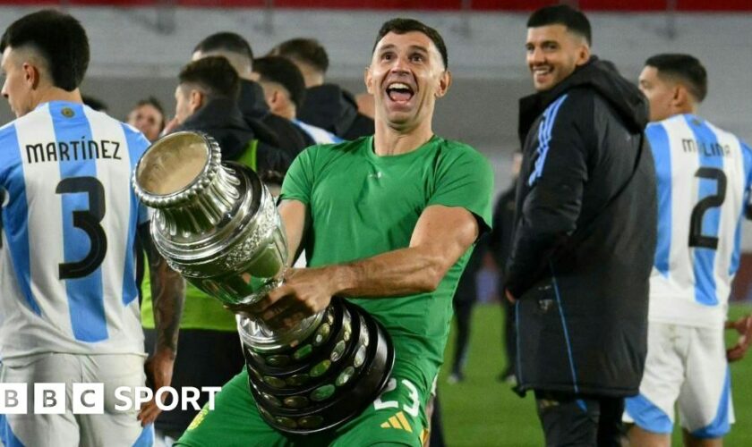 Argentina goalkeeper Emiliano Martinez holds a replica Copa America trophy against his crotch