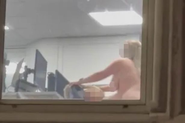 Moment randy office workers caught having sex in office in full view of busy street