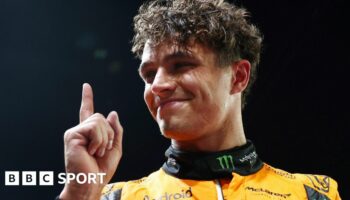 Lando Norris lifts his index finger in celebration after taking pole position for the Singapore Grand Prix