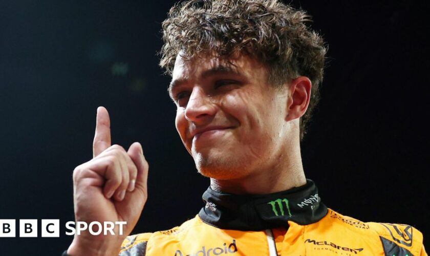 Lando Norris lifts his index finger in celebration after taking pole position for the Singapore Grand Prix