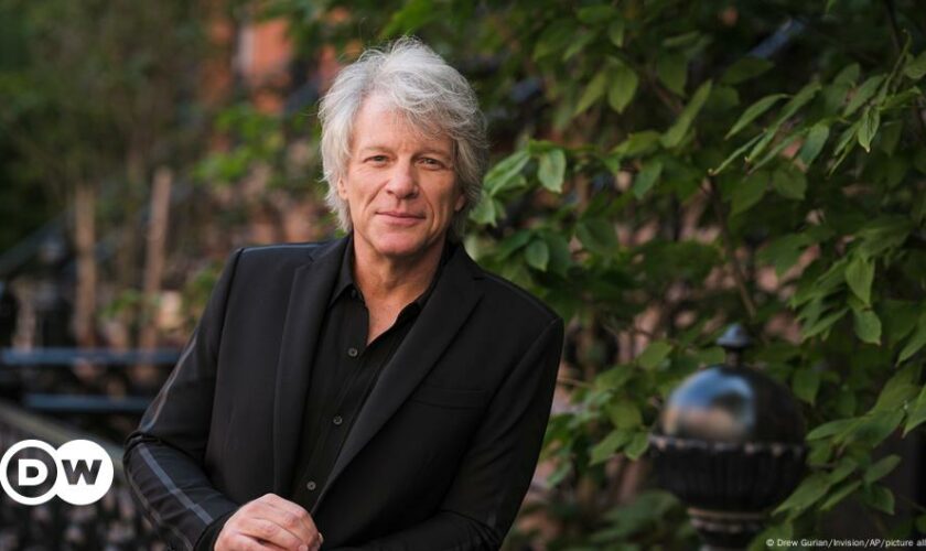 US musician Jon Bon Jovi helps woman standing on bridge edge