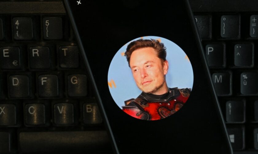 Cette photographie d'illustration montre une photographie du PDG du réseau social X, Elon Musk, affichée sur un smartphone à Bruxelles le 27 septembre 2024. (Photo de Nicolas TUCAT / AFP)