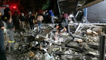 People work to clear debris after an airstrike that hit an apartment building in Beirut. Pic: AP Photo/Hussein Malla