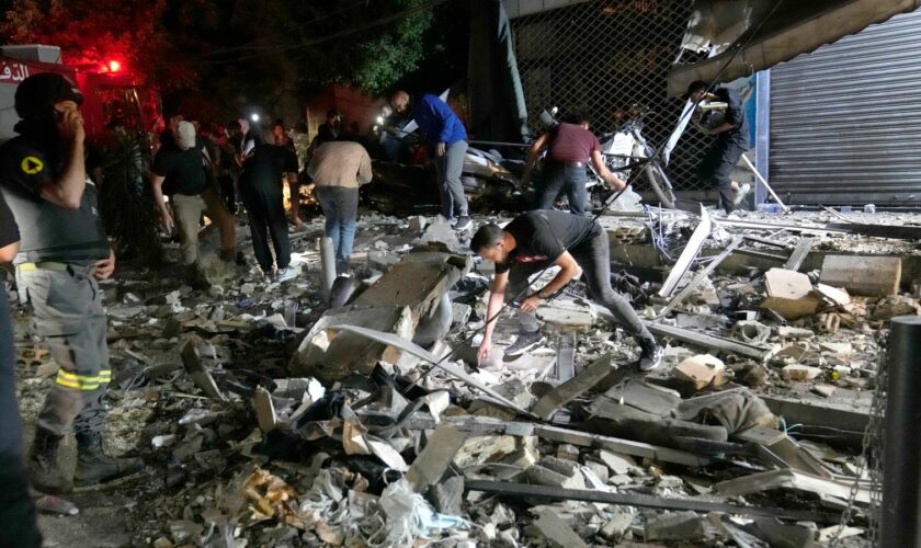 People work to clear debris after an airstrike that hit an apartment building in Beirut. Pic: AP Photo/Hussein Malla