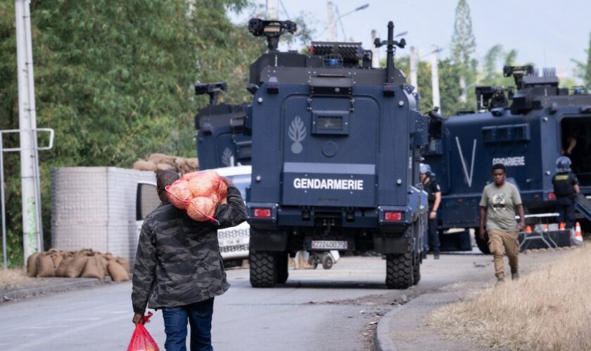 Un homme transporte des vivre près d'un barrage de la gendarmerie, à Saint-Louis, en Nouvelle-Calédonie, le 23 septembre 2024