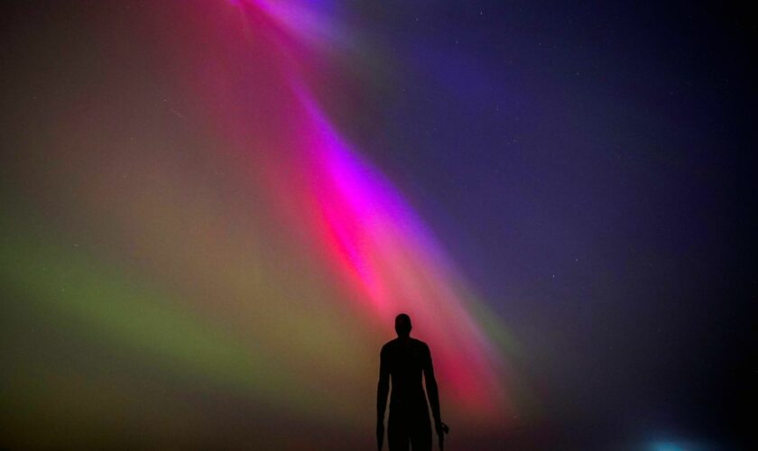 The aurora borealis, also known as the northern lights, glow on the horizon at Another Place by Anthony Gormley, Crosby Beach, Liverpool , Merseyside . Picture date: Friday May 10, 2024. PA Photo. See PA story WEATHER Aurora. Photo credit should read: Peter Byrne/PA Wire