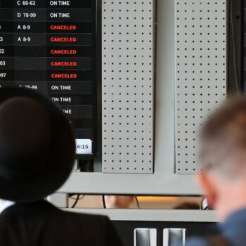 Des passagers devant un tableau d'affichage de l'aéroport Ben Gourion de Tel-Aviv, le 6 août 2024