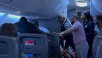 Passengers intervene on flight when man allegedly attacks woman next to him, video shows