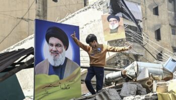 Un garçon se tient près de l'affiche du chef du Hezbollah Hassan Nasrallah parmi les destructions provoquées par les attaques de l'armée israélienne sur Dahiyeh, à Beyrouth, Liban, le 02 octobre 2024.