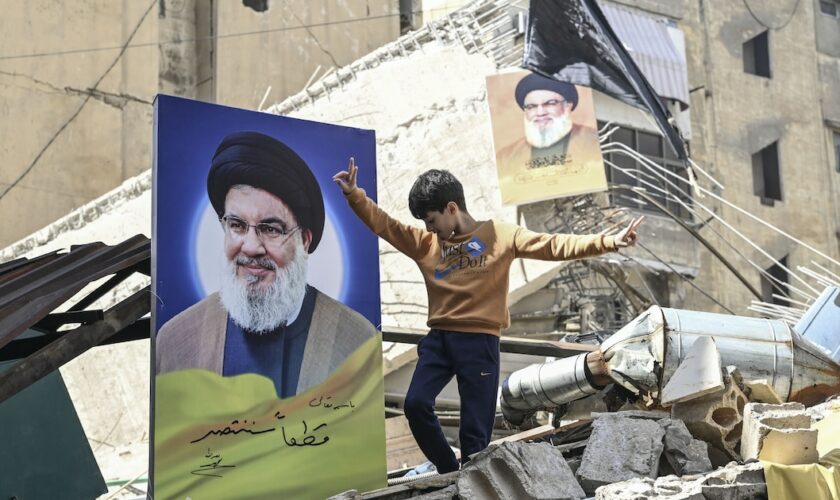 Un garçon se tient près de l'affiche du chef du Hezbollah Hassan Nasrallah parmi les destructions provoquées par les attaques de l'armée israélienne sur Dahiyeh, à Beyrouth, Liban, le 02 octobre 2024.