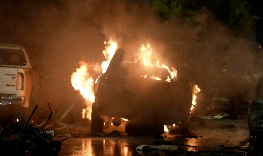 A vehicle is seen on fire at the site of an explosion that caused injures and destroyed vehicles at outside the Karachi airport, Pakistan, Sunday, Oct. 6, 2024. (AP Photo/Mohammad Farooq)