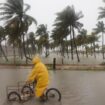 A person rides his bike through a flooded street in the rain in Progreso, Yucatan state, Mexico. Pic: AP