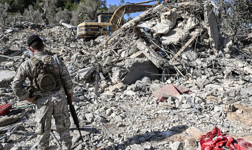 Un soldat de l'armée libanaise se tient près des décombres d'un bâtiment détruit par une frappe israélienne, dans le village d'Aito dans le nord du Liban, le 15 octobre 2024.