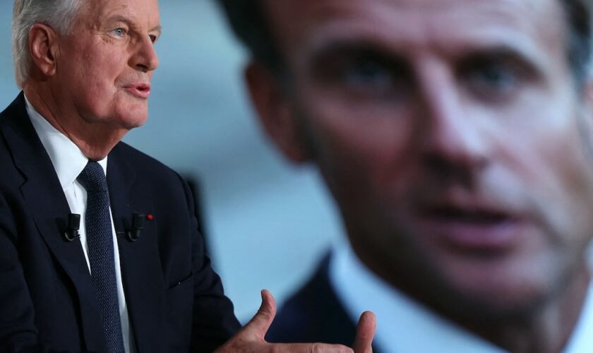 Le Premier ministre français Michel Barnier s'exprime à côté d'un écran affichant une photo du président français Emmanuel Macron lors de l'émission politique "L'Événement" diffusée sur la chaîne de télévision française France 2