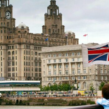 A young passenger looks at the Liverpool skyline as the Mersey Ferry comes into dock. Pic: Reuters