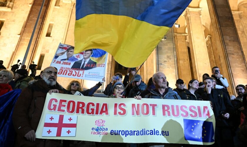 Une banderole "La Géorgie n'est pas la Russie", surmontée d'un drapeau ukrainien, le 28 octobre 2024 dans une manifestation pro-européenne à Tbilissi