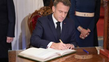 Le président français Emmanuel Macron, accompagné de son épouse Brigitte, signe le livre d'or à la fin d'une visite au mausolée de Mohamed V à Rabat, le 29 octobre 2024.