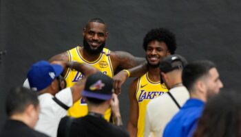 LeBron James und sein Sohn Bronny lächeln im gelben Lakers-Trikot für die Fotografen