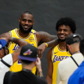 LeBron James und sein Sohn Bronny lächeln im gelben Lakers-Trikot für die Fotografen